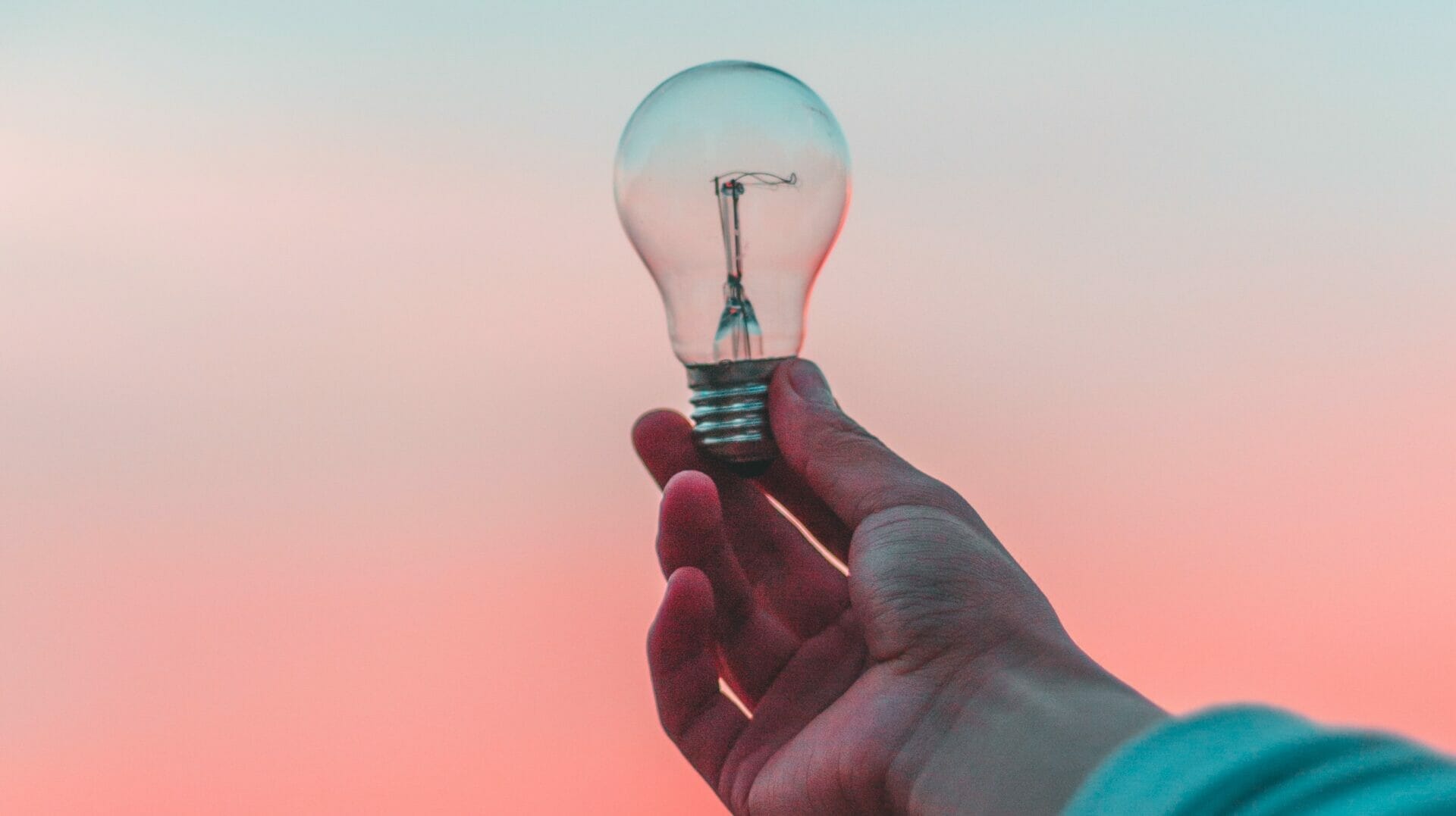 A lightbulb against a pink sky that represents knowing your ideal multiple