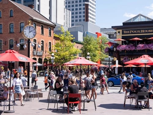 Woman walking down the street with a mobile device in Toronto, Canada